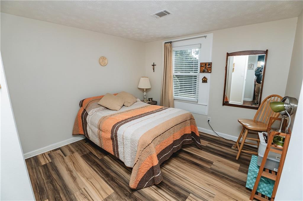 3184 Newcastle Way Snellville, GA 30039 - Photo 20 of 36 a bedroom with a bed and wooden floor