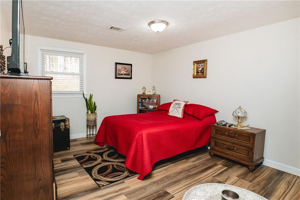 3184 Newcastle Way Snellville, GA 30039 - Photo 24 of 36 a bedroom with a bed and wooden floor