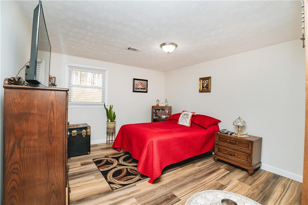 3184 Newcastle Way Snellville, GA 30039 - Photo 25 of 36 a bedroom with a bed and wooden floor