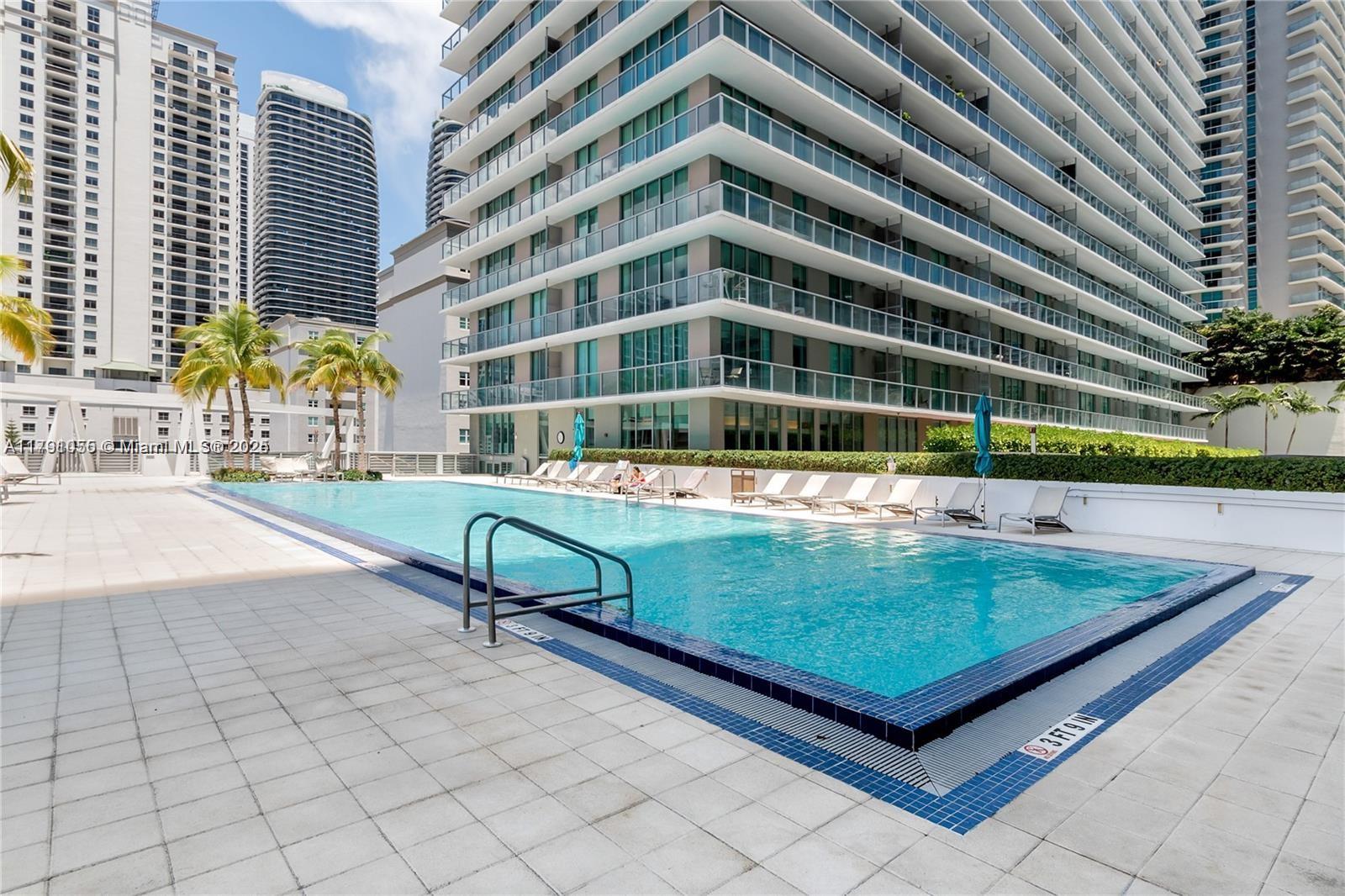 79 Southwest 12th Street, Unit 1710S Miami, FL 33130 - Photo 17 of 18 a view of a swimming pool with a lounge chairs