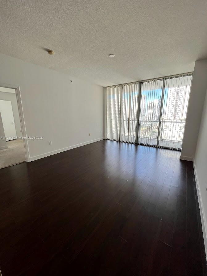 79 Southwest 12th Street, Unit 1710S Miami, FL 33130 - Photo 3 of 18 a view of an empty room with wooden floor and a window