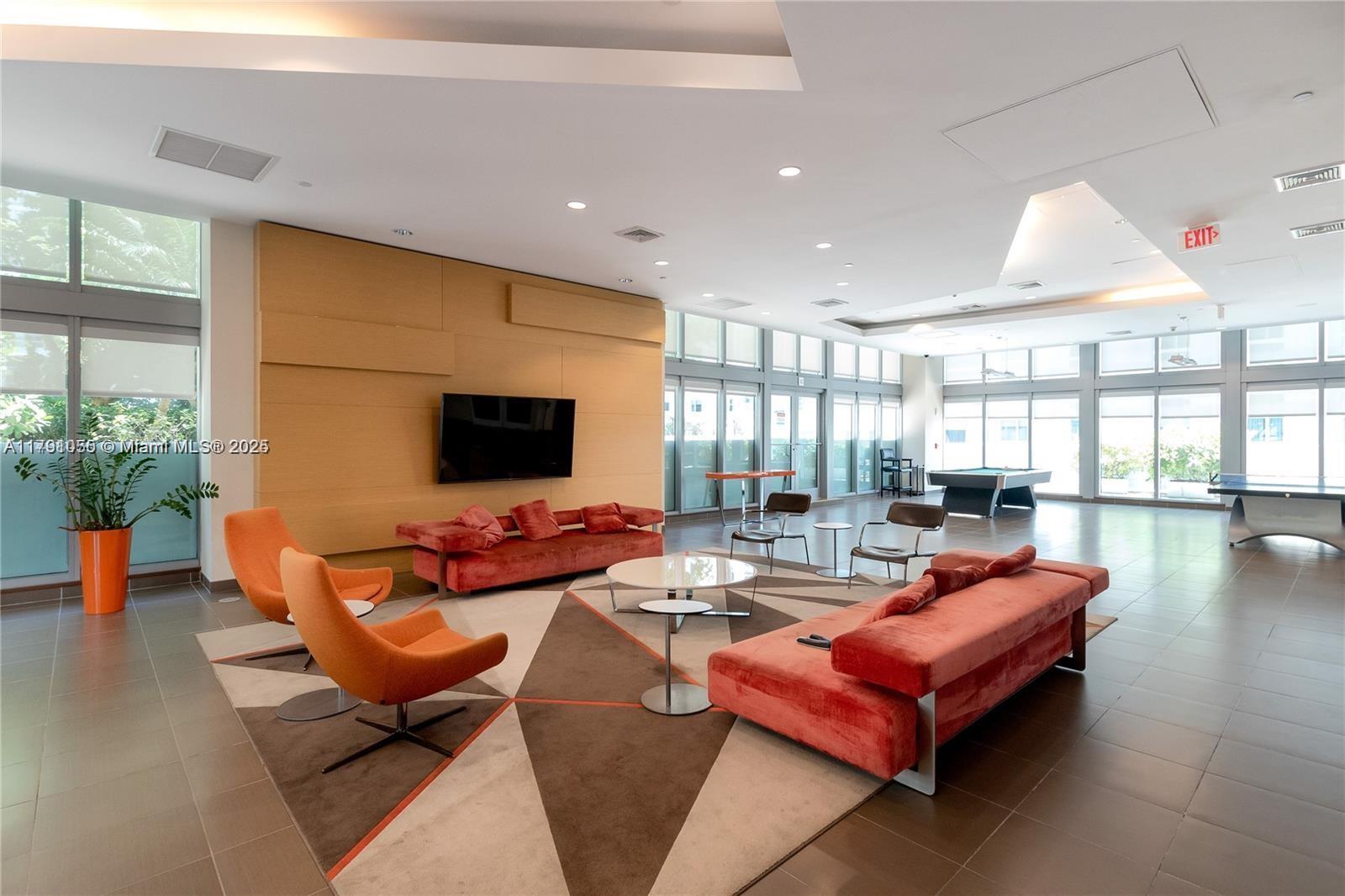 79 Southwest 12th Street, Unit 1710S Miami, FL 33130 - Photo 9 of 18 a living room with furniture and a flat screen tv