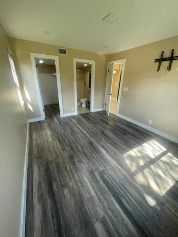 a view of empty room with wooden floor