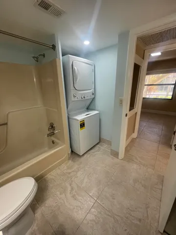 a spacious bathroom with a tub a toilet and a shower