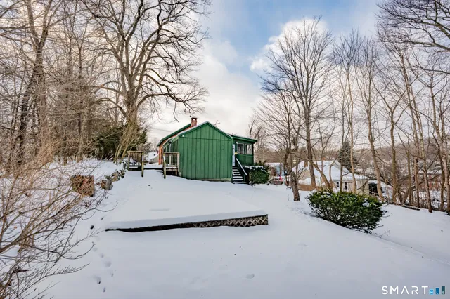 a view of a white house with a yard covered in snow