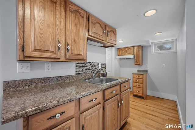 a kitchen with stainless steel appliances granite countertop a sink stove and cabinets