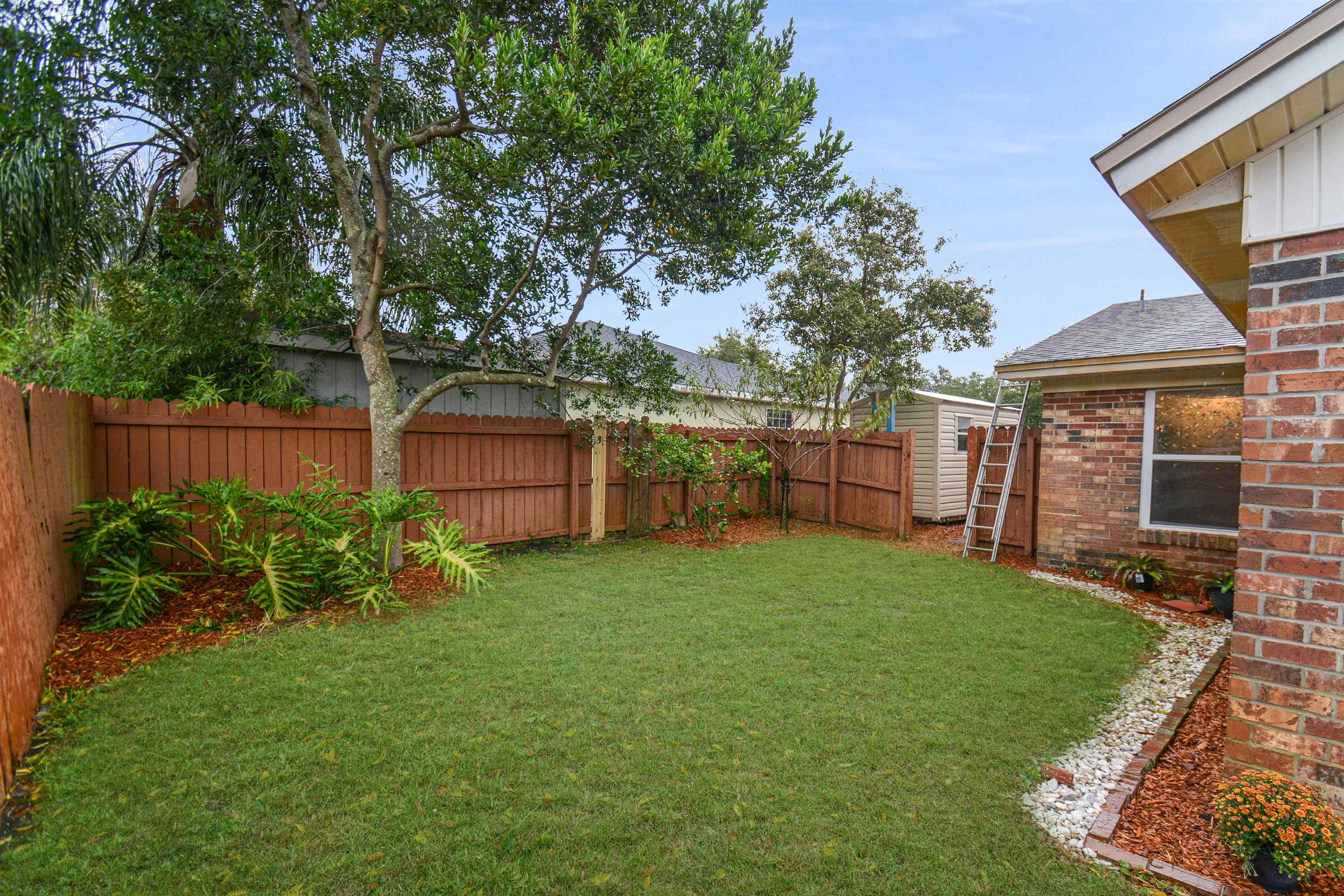 424 Segovia Road St. Augustine, FL 32086 - Photo 24 of 25 a view of a backyard with table and chairs and wooden fence