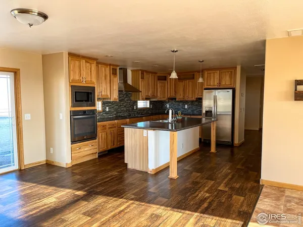 a kitchen with granite countertop a refrigerator and a stove top oven