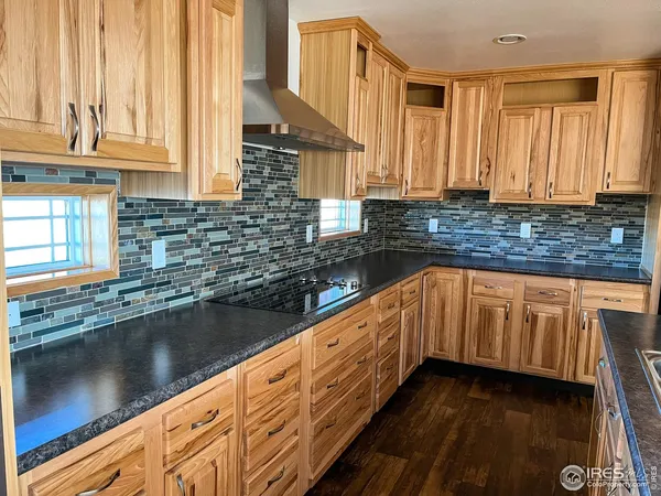 a kitchen with granite countertop a sink a stove and cabinets