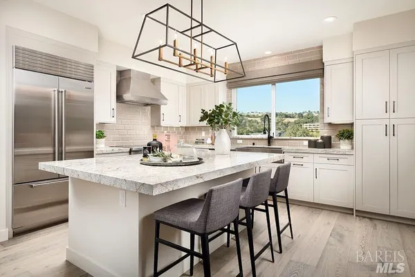 a kitchen with kitchen island a large counter top space appliances and cabinets