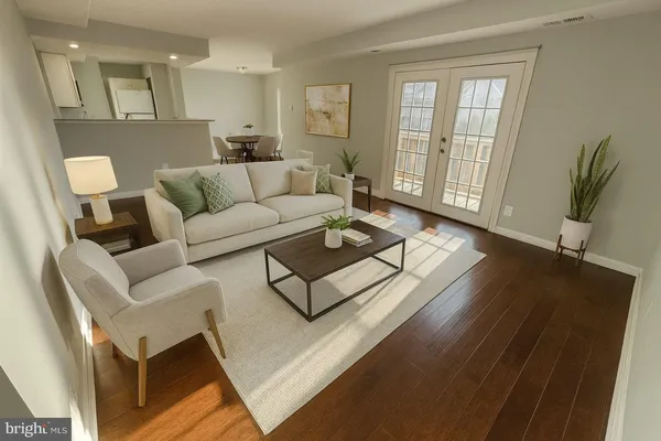 a living room with furniture and a wooden floor