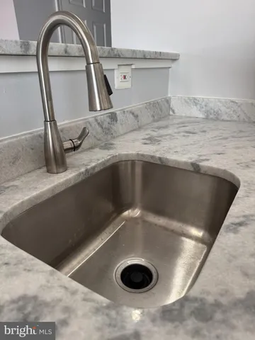 a view of a kitchen counter top a sink and a stove with wooden floors