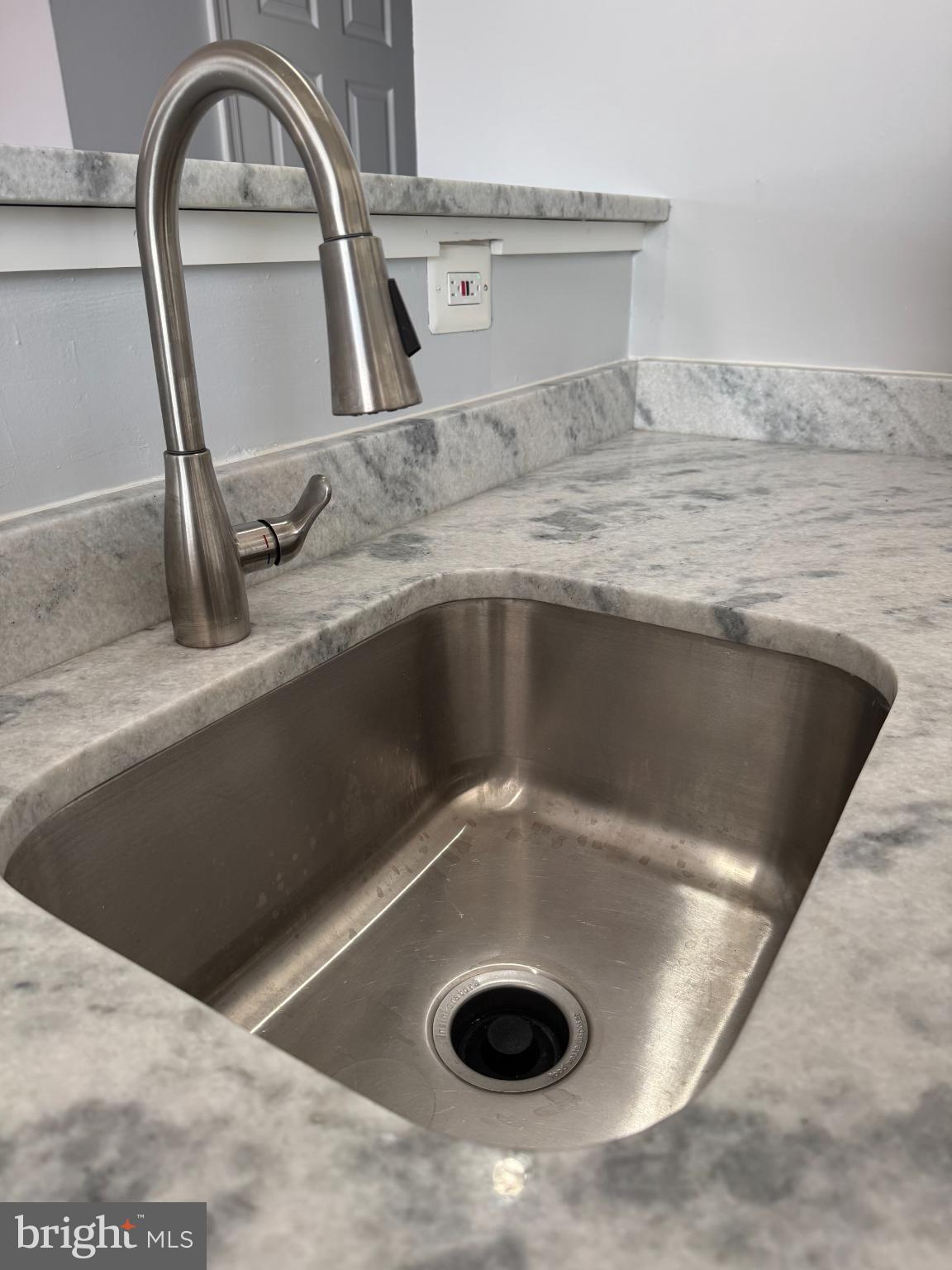 2500 Markham Lane, Unit 2 Landover, MD 20785 - Photo 12 of 27 a view of a kitchen counter top a sink and a stove with wooden floors