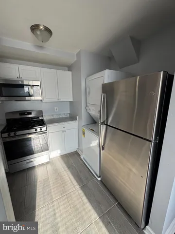 a kitchen with stainless steel appliances a refrigerator and a stove top oven