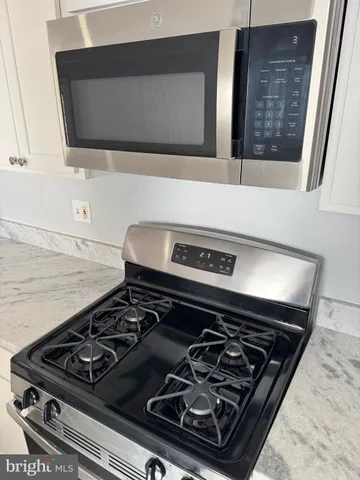 a stove sitting inside of a kitchen with white cabinets