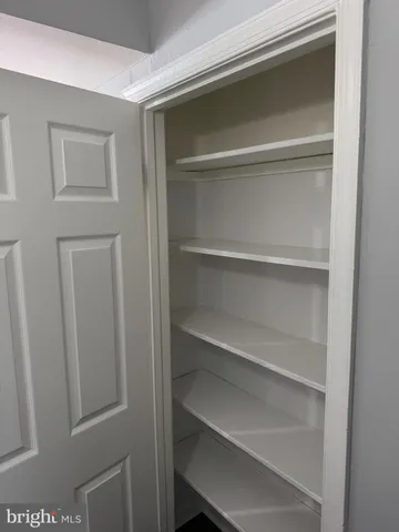 a view of walk in closet with empty racks