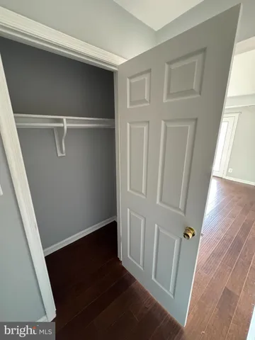 a view of walk in closet with wooden floor