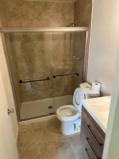 a bathroom with a sink a toilet and shower