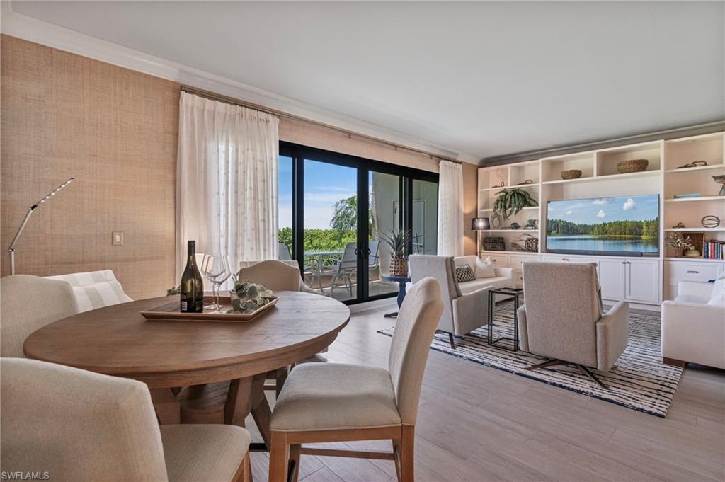 176 South Collier Boulevard, Unit 101 Marco Island, FL 34145 - Photo 11 of 50 a dining room with furniture and wooden floor