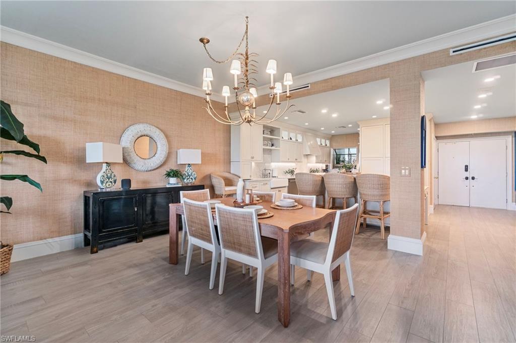 176 South Collier Boulevard, Unit 101 Marco Island, FL 34145 - Photo 15 of 50 a view of a dining room with furniture and wooden floor