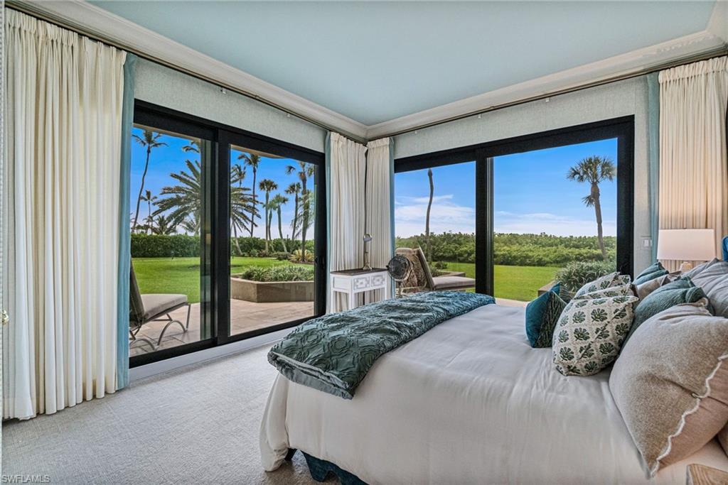 176 South Collier Boulevard, Unit 101 Marco Island, FL 34145 - Photo 2 of 50 a bed sitting in a bedroom next to a large window with outer view