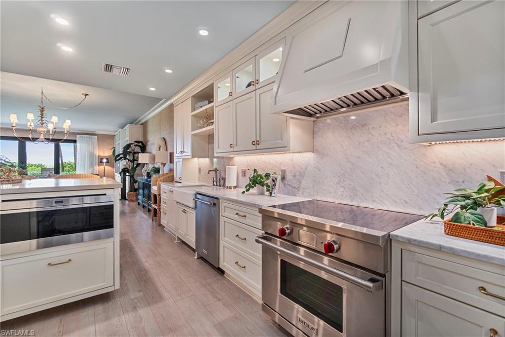 176 South Collier Boulevard, Unit 101 Marco Island, FL 34145 - Photo 22 of 50 a kitchen with a stove and white cabinets