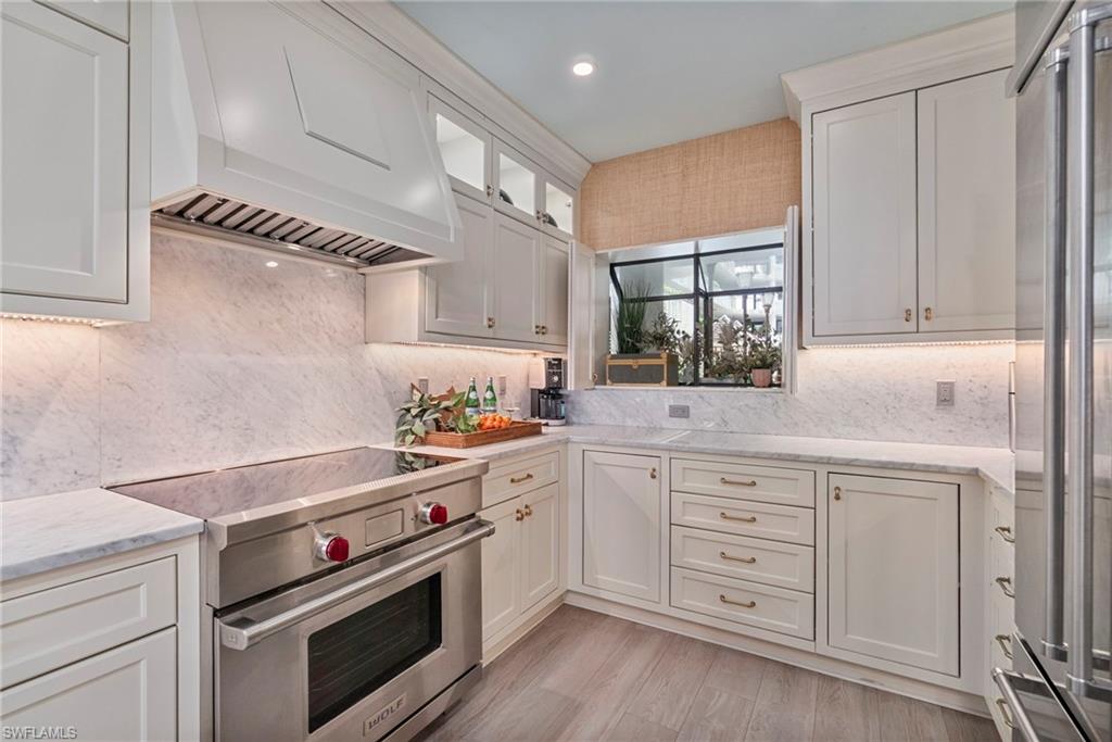 176 South Collier Boulevard, Unit 101 Marco Island, FL 34145 - Photo 3 of 50 a kitchen with white cabinets stainless steel appliances and sink