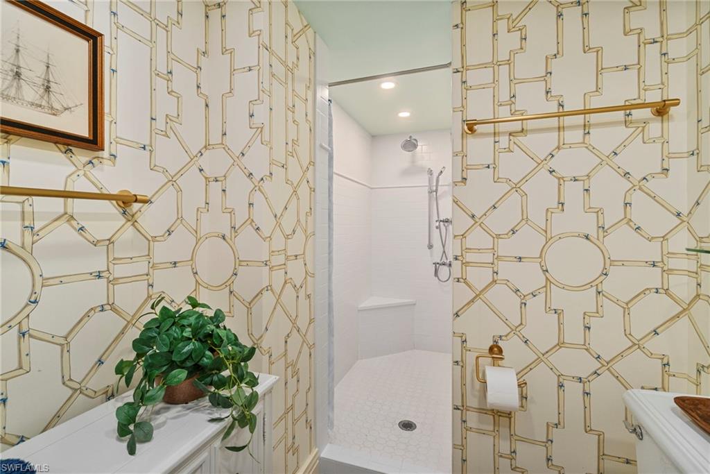176 South Collier Boulevard, Unit 101 Marco Island, FL 34145 - Photo 36 of 50 a bathroom with a shower curtain and a sink