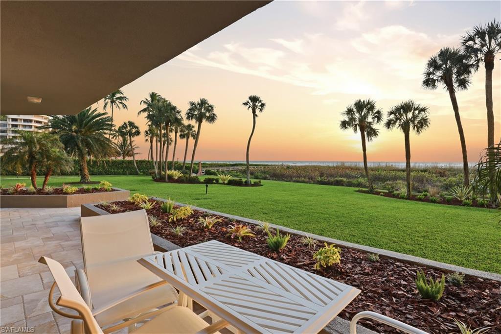 176 South Collier Boulevard, Unit 101 Marco Island, FL 34145 - Photo 41 of 50 a view of a patio with a table chairs and a swimming pool