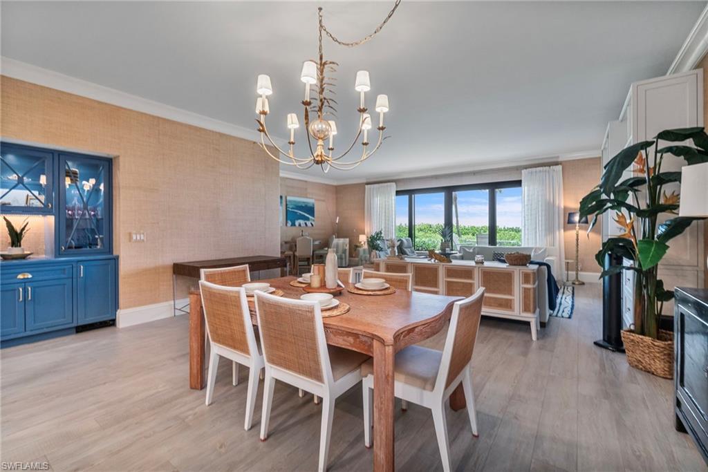 176 South Collier Boulevard, Unit 101 Marco Island, FL 34145 - Photo 5 of 50 a view of a dining room with furniture window and wooden floor