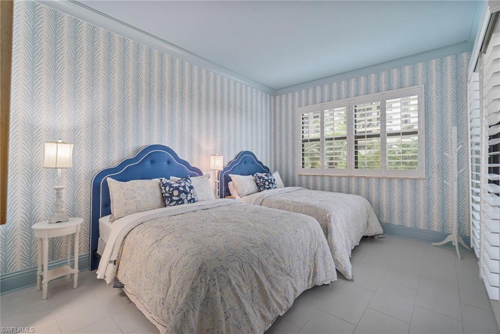 176 South Collier Boulevard, Unit 101 Marco Island, FL 34145 - Photo 7 of 50 a bedroom with two beds and a window