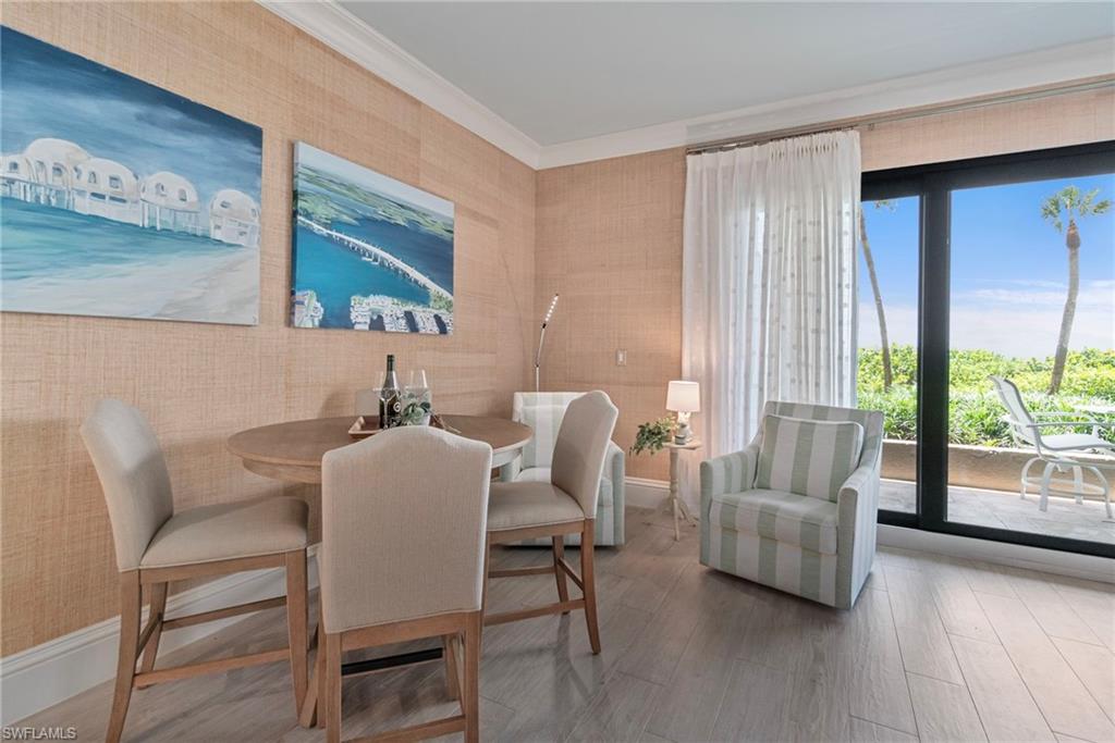 176 South Collier Boulevard, Unit 101 Marco Island, FL 34145 - Photo 10 of 50 a dining room with furniture and wooden floor