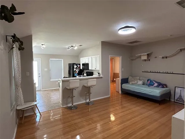 a living room with furniture and a wooden floor