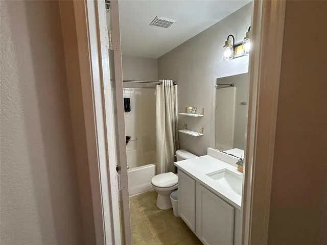 a bathroom with a granite countertop sink mirror vanity and a toilet