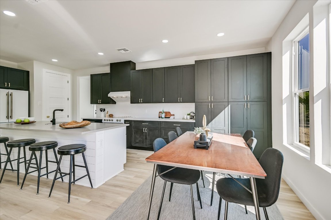 52 War Bonnet Wimberley, TX 78676 - Photo 8 of 31 a kitchen with a table chairs a sink dishwasher window and cabinets