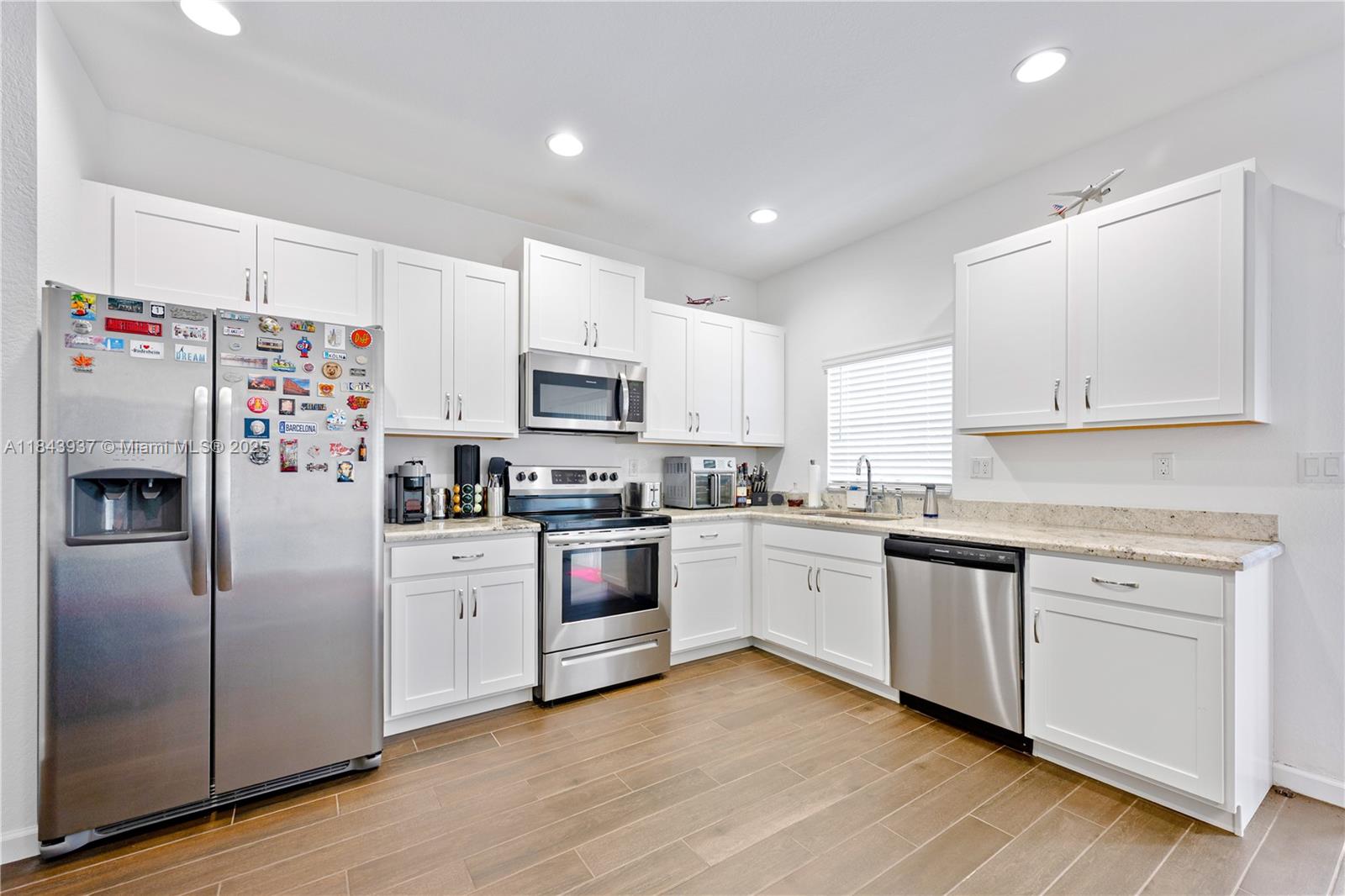a kitchen with white cabinets and white appliances