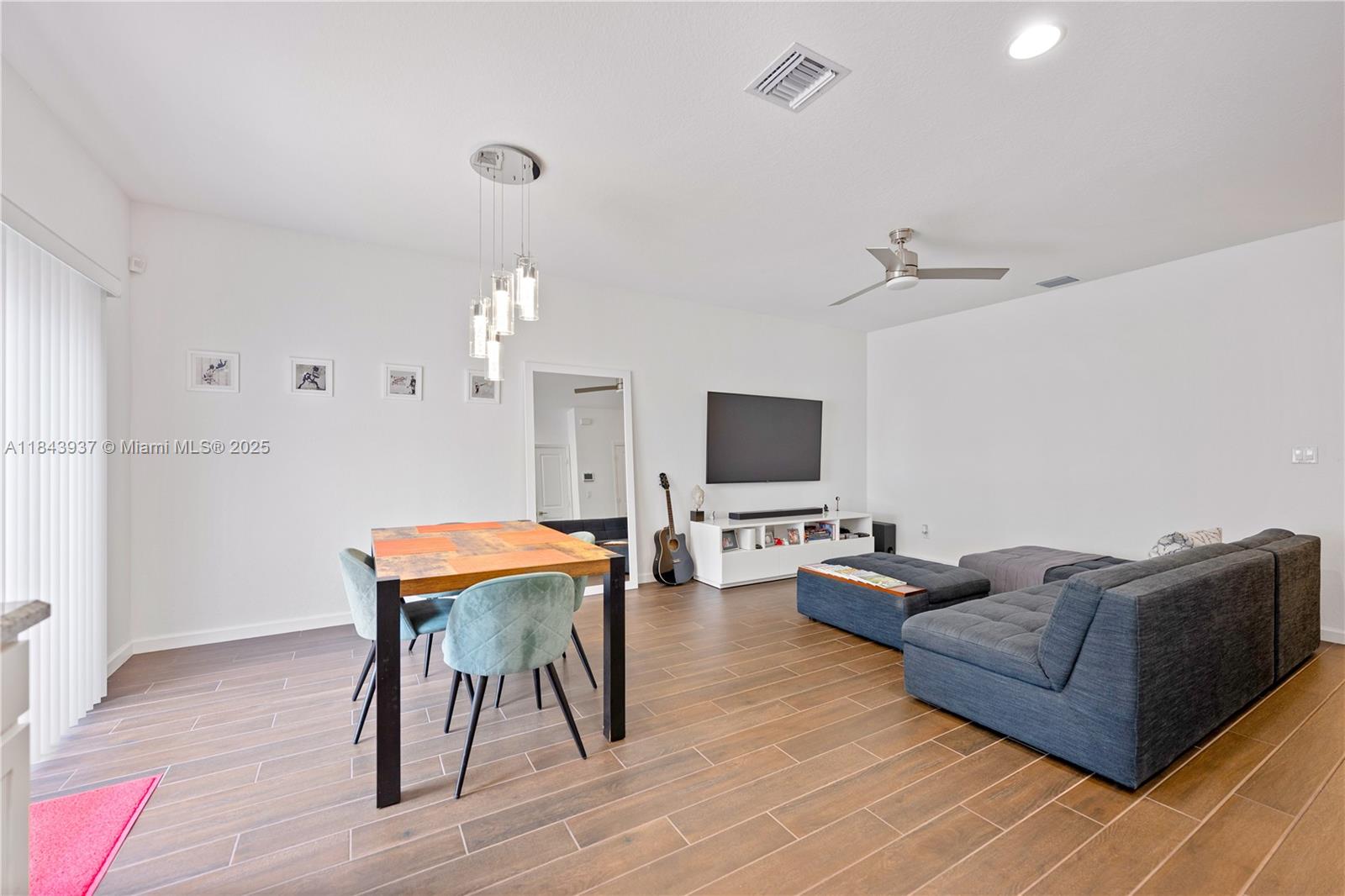 1106 Northwest 40th Terrace Lauderhill, FL 33313 - Photo 3 of 20 a living room with furniture a flat screen tv and a chandelier