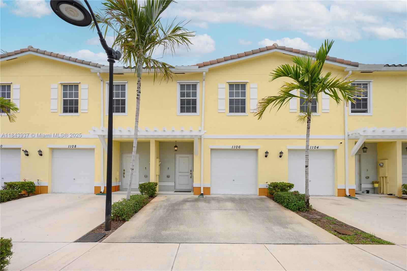 1106 Northwest 40th Terrace Lauderhill, FL 33313 - Photo 4 of 20 a view of a white house with a yard and potted plants