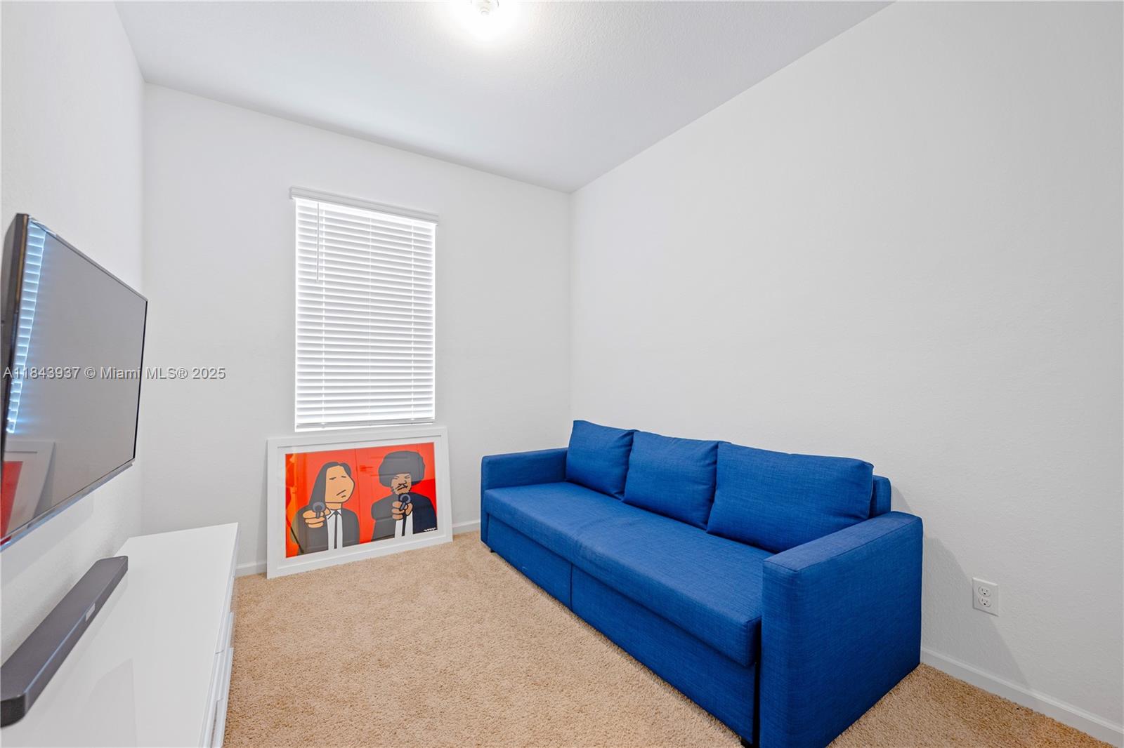 1106 Northwest 40th Terrace Lauderhill, FL 33313 - Photo 10 of 20 a blue couch sitting in a living room with blue walls