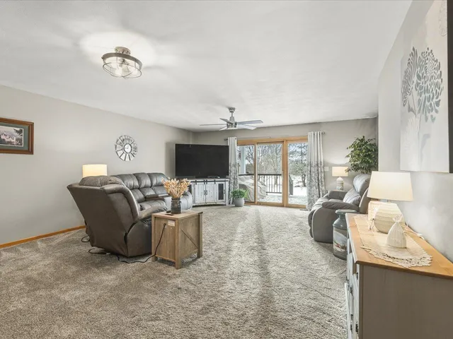 a living room with furniture a flat screen tv and a large window