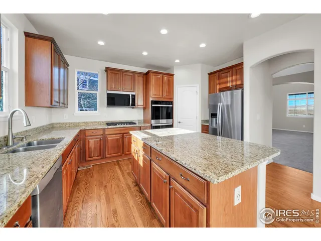 a kitchen with stainless steel appliances granite countertop a sink stove and cabinets