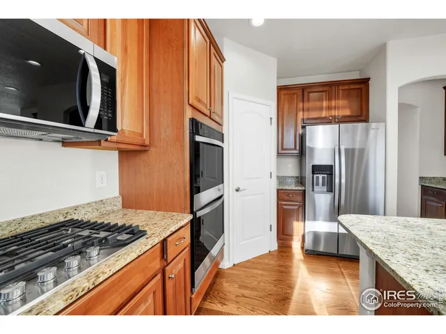 a kitchen with stainless steel appliances granite countertop a refrigerator and a stove top oven