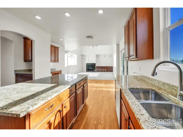 a kitchen with granite countertop a sink and wooden cabinets