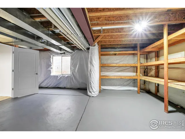 a view of an empty room with wooden floor and cabinets