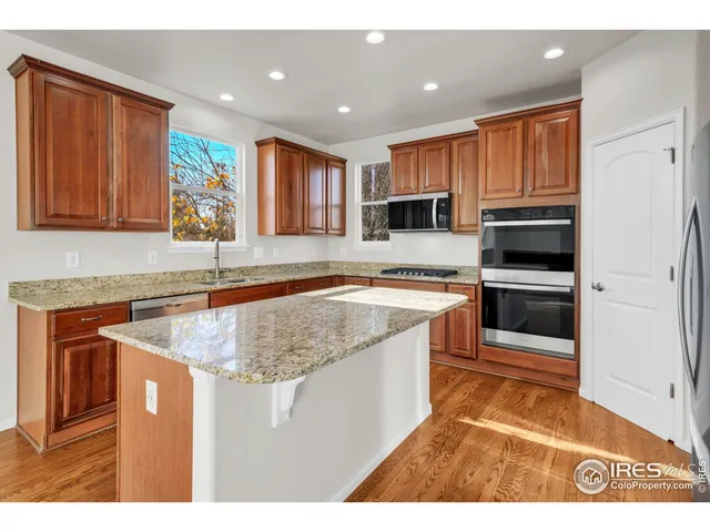 a kitchen with stainless steel appliances granite countertop a sink a stove and a microwave oven