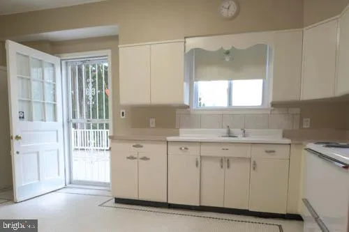 a kitchen with white cabinets and a sink