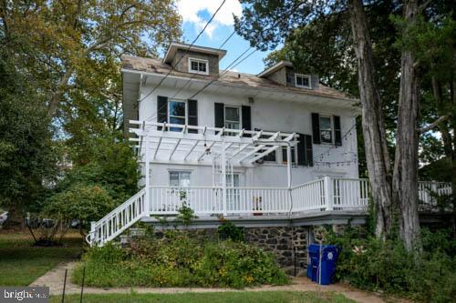 2504 Queen Anne Road Baltimore, MD 21216 - Photo 29 of 36 a view of a white house with large trees and plants