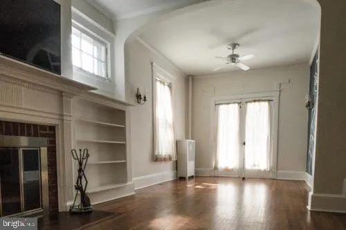 a view of an empty room with a window and wooden floor