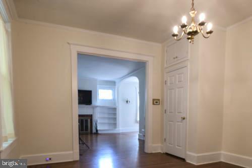 2504 Queen Anne Road Baltimore, MD 21216 - Photo 10 of 36 a view of a hallway with wooden floor and a chandelier