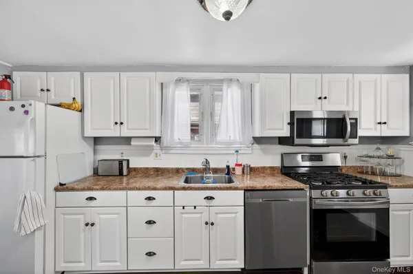 a kitchen with granite countertop white cabinets and white appliances